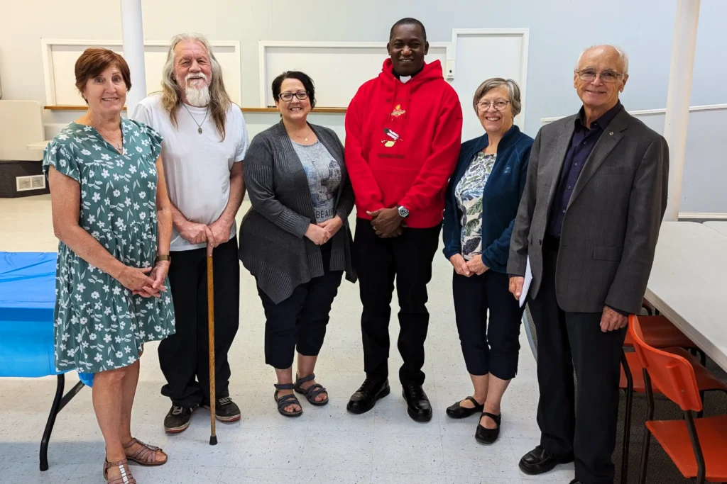 Beausejour Parish members stand with Father Sebastian